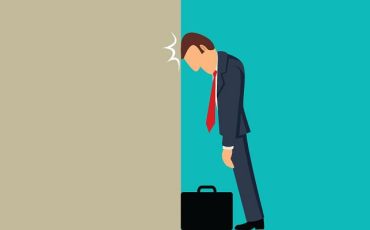 رسم يوضح رجل أعمال يضرب رأسه في حائط، يمثل أخطاء شائعة أو تحديات في ريادة الأعمال قد تؤدي إلى الفشل.